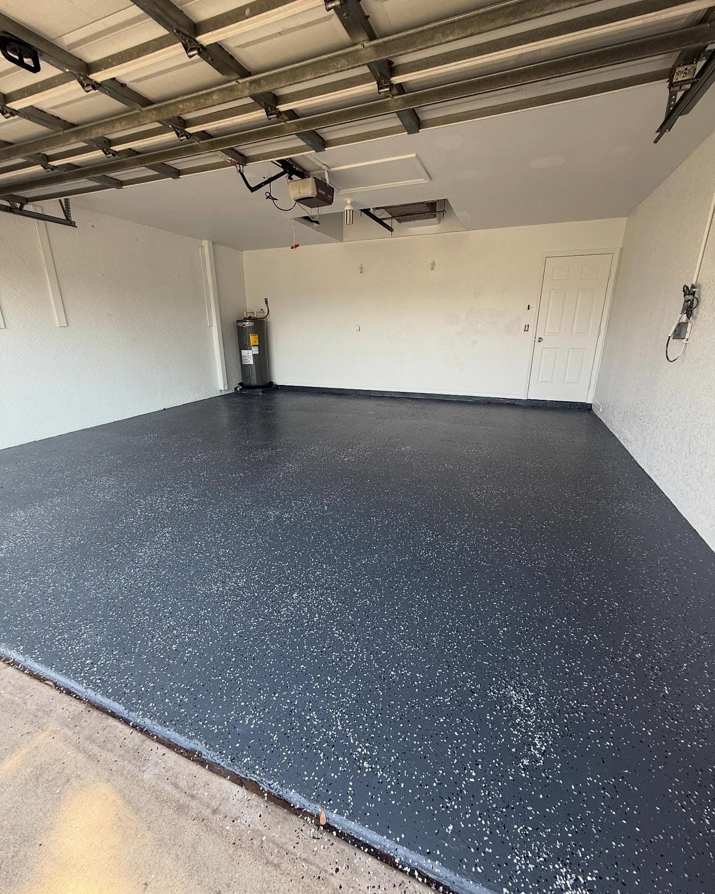 Garage floor makeover by I&I Home Repair, after: dark gray coated floor with a white flake finish